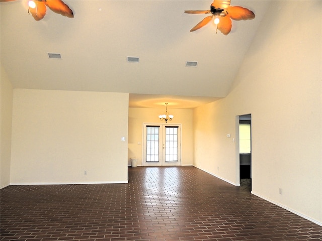 unfurnished room with a towering ceiling, ceiling fan with notable chandelier, and french doors