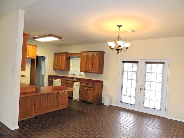 kitchen featuring pendant lighting, an inviting chandelier, white dishwasher, and sink