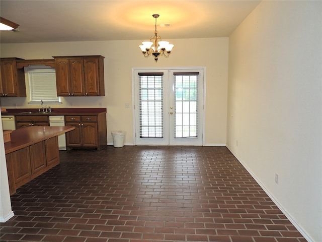 kitchen featuring dishwasher, sink, decorative light fixtures, and an inviting chandelier