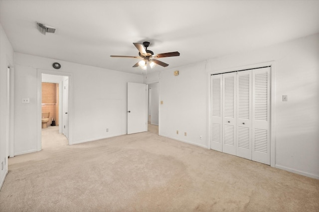 unfurnished bedroom with ceiling fan, light carpet, and ensuite bath