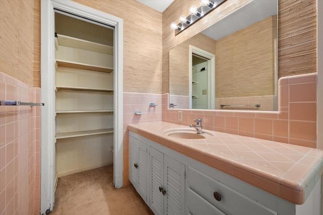 bathroom featuring vanity and tile walls