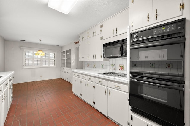 kitchen with decorative backsplash, black appliances, tile countertops, white cabinets, and hanging light fixtures