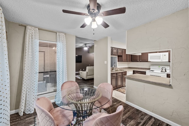 dining room featuring a textured ceiling, ceiling fan, dark hardwood / wood-style floors, and sink