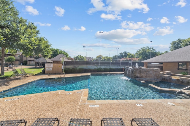 view of pool with pool water feature, an outdoor structure, and a patio area