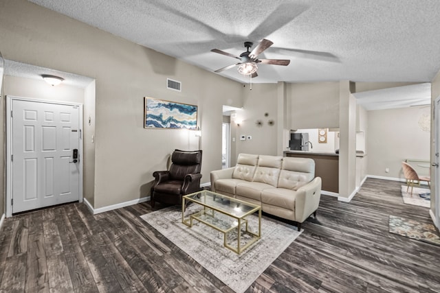 living room featuring a textured ceiling, dark hardwood / wood-style flooring, ceiling fan, and vaulted ceiling