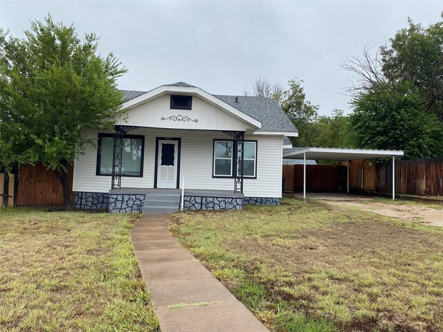 view of front of house with a carport and a front yard