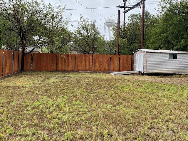 view of yard featuring a storage unit, an outdoor structure, and a fenced backyard