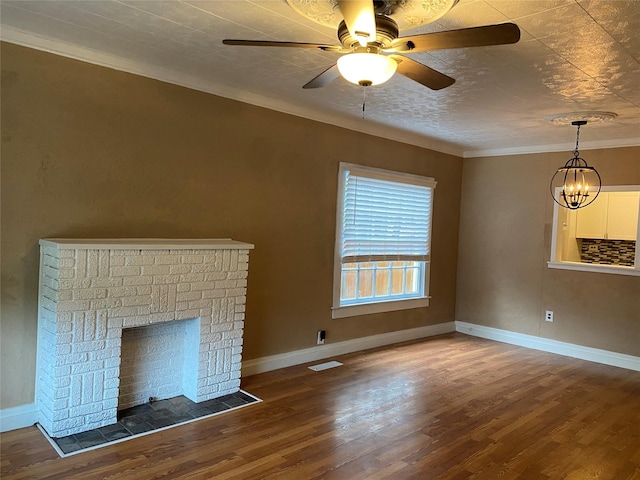 unfurnished living room featuring visible vents, baseboards, wood finished floors, crown molding, and a brick fireplace