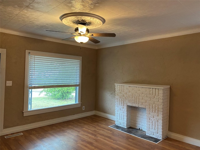 unfurnished living room with ceiling fan, wood finished floors, visible vents, and crown molding