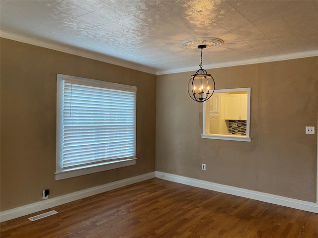 unfurnished room featuring crown molding, visible vents, a notable chandelier, and wood finished floors