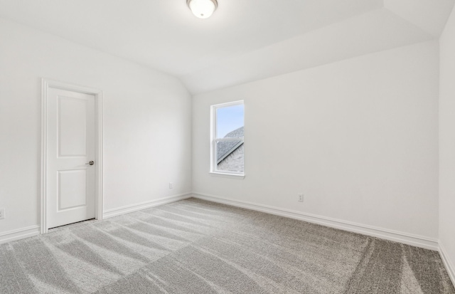 unfurnished room with vaulted ceiling and carpet floors