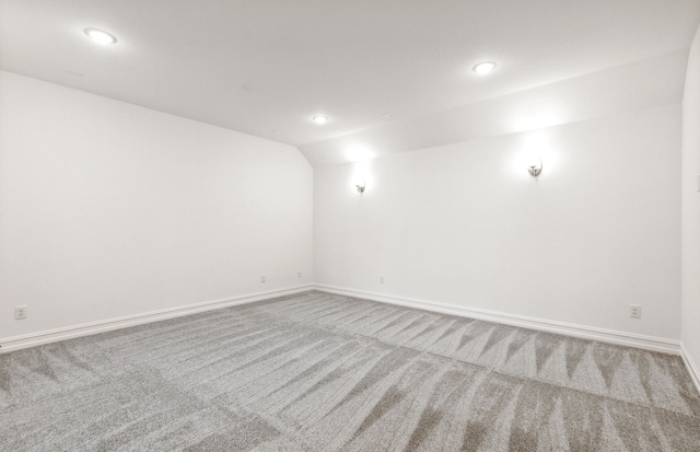 carpeted spare room with lofted ceiling