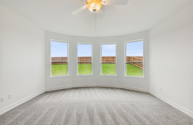 carpeted empty room featuring ceiling fan and a healthy amount of sunlight