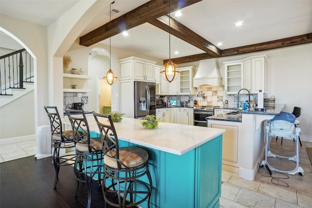 kitchen featuring hanging light fixtures, a kitchen bar, custom exhaust hood, and stainless steel appliances