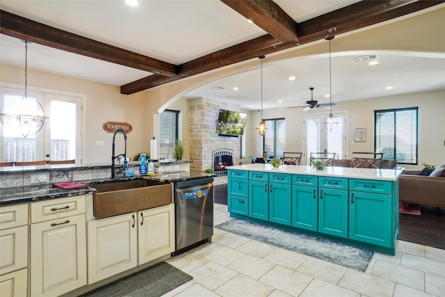 kitchen featuring dishwasher, decorative light fixtures, ceiling fan, and a stone fireplace