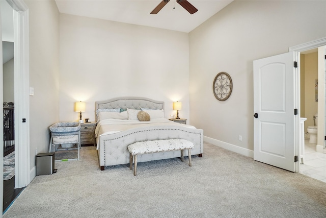 bedroom with high vaulted ceiling, ceiling fan, light colored carpet, and connected bathroom