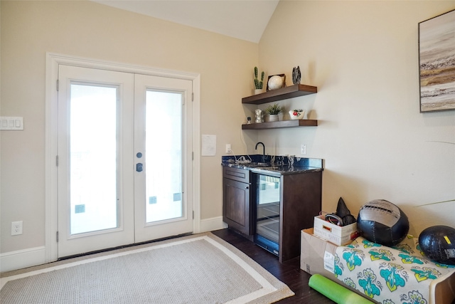 kitchen featuring dark wood-type flooring, lofted ceiling, beverage cooler, and sink