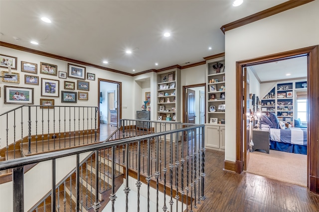 hallway with built in features, dark hardwood / wood-style floors, and crown molding