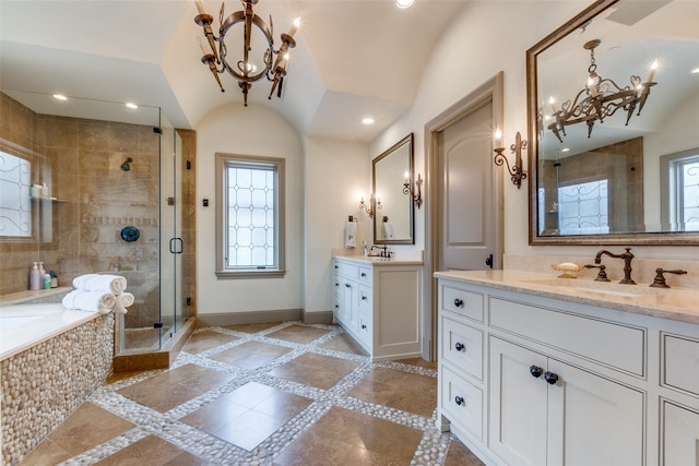 bathroom with vaulted ceiling, independent shower and bath, an inviting chandelier, and vanity