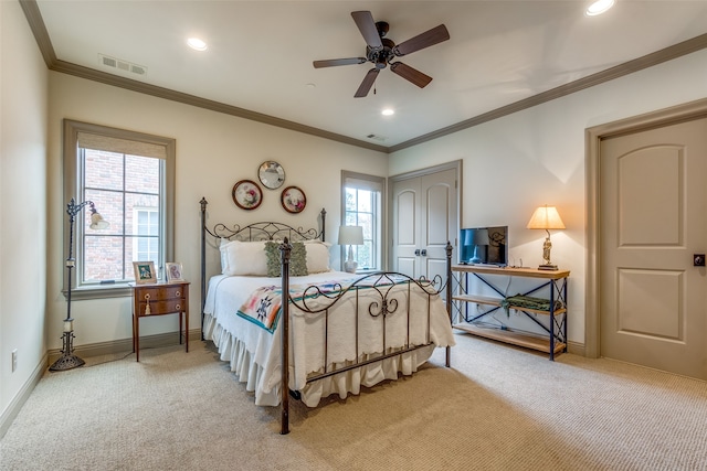 carpeted bedroom with crown molding, ceiling fan, and a closet