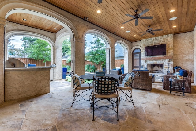 view of patio / terrace featuring an outdoor stone fireplace and ceiling fan