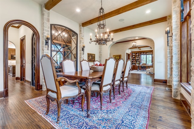 dining space with dark hardwood / wood-style floors, lofted ceiling with beams, and a notable chandelier