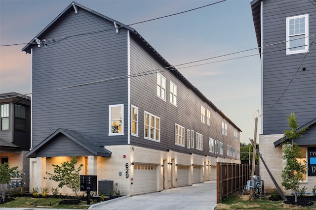 view of front of property with a garage and central air condition unit