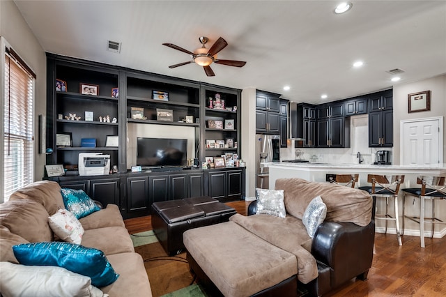 living room featuring dark wood-type flooring and ceiling fan