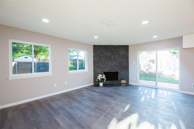 unfurnished living room with recessed lighting, a fireplace, baseboards, and wood finished floors