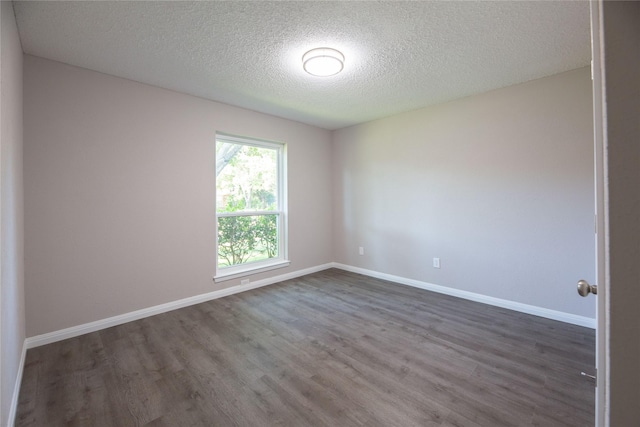 unfurnished room with dark wood-style flooring, a textured ceiling, and baseboards