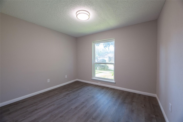 unfurnished room featuring dark wood-style flooring, a textured ceiling, and baseboards