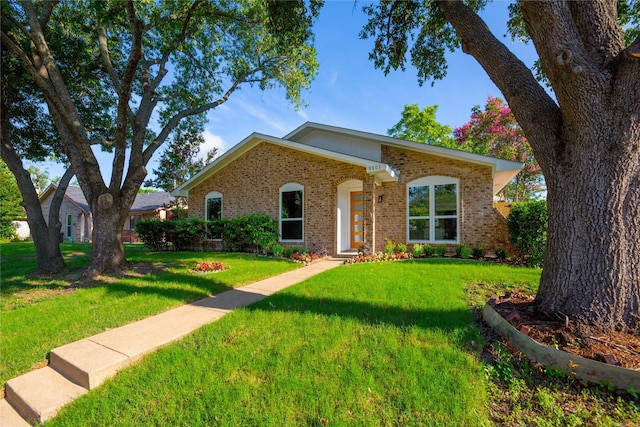 view of front of house featuring a front yard and brick siding