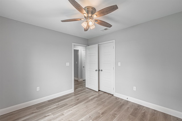 unfurnished bedroom with light wood-type flooring, ceiling fan, and a closet