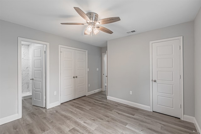 unfurnished bedroom with light wood-type flooring, ensuite bath, and ceiling fan