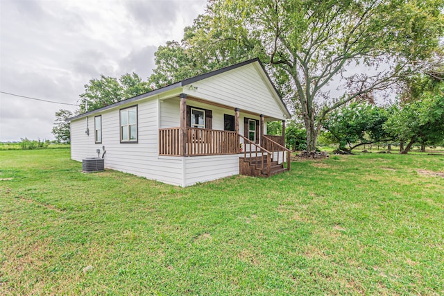 view of front of property featuring a front yard, covered porch, and central air condition unit