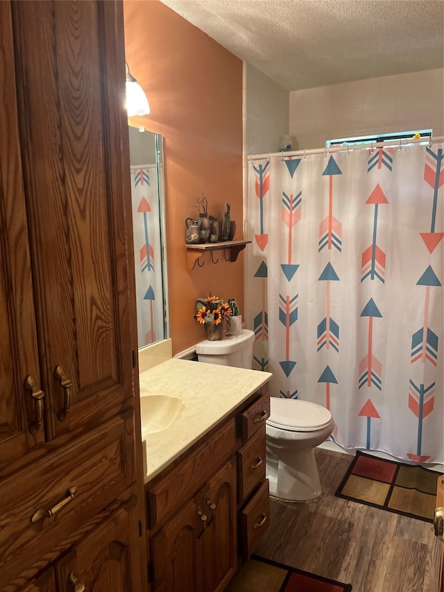 bathroom with toilet, vanity, a textured ceiling, and hardwood / wood-style flooring