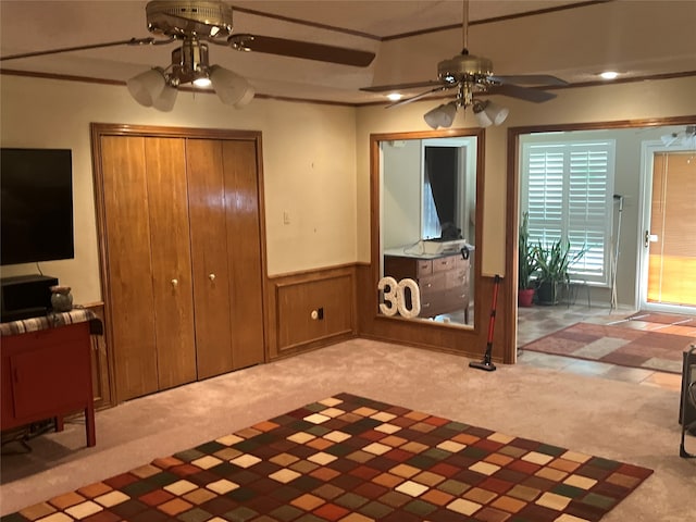 carpeted living room with ceiling fan and wooden walls