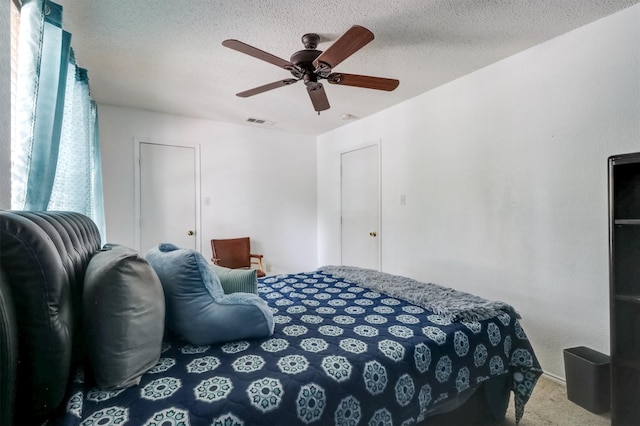 carpeted bedroom with a textured ceiling and ceiling fan