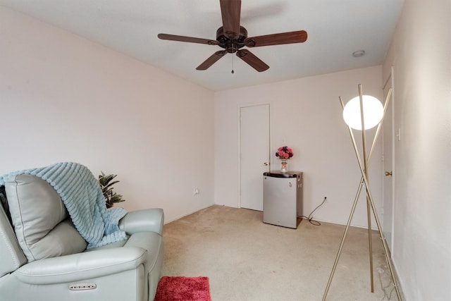 living area with ceiling fan and light colored carpet