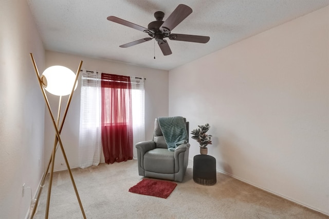 sitting room with light colored carpet, ceiling fan, and a textured ceiling