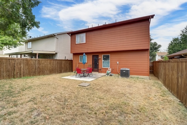 rear view of property with a lawn, a patio area, and central AC unit