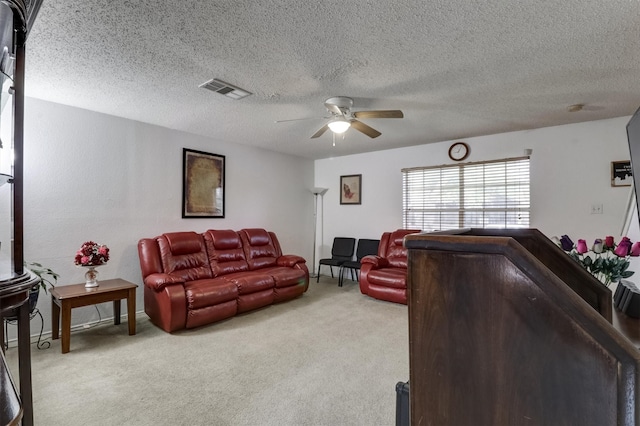 carpeted living room with a textured ceiling and ceiling fan