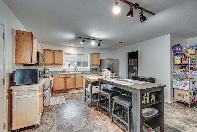 kitchen featuring stainless steel appliances, sink, a textured ceiling, a kitchen island, and wood counters