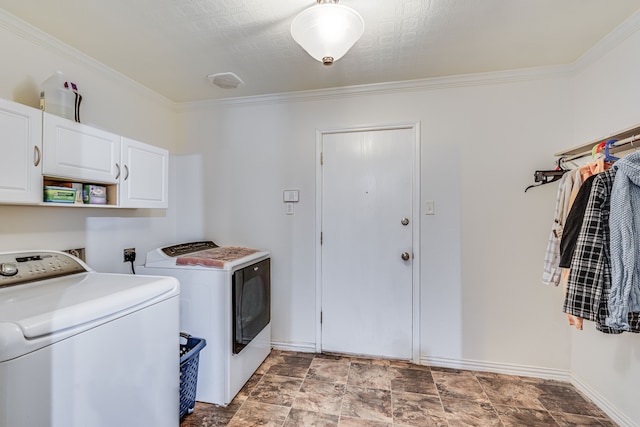 laundry area featuring cabinets, crown molding, and washing machine and clothes dryer