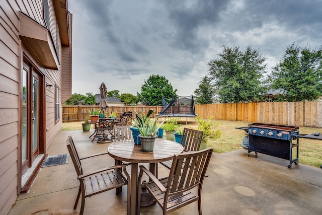 view of patio with a trampoline and a grill