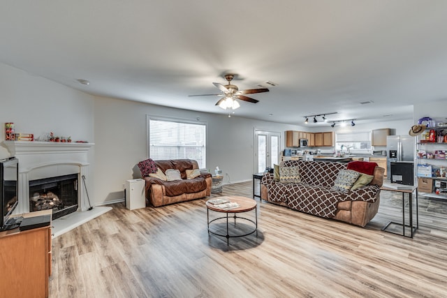 living room with ceiling fan and light hardwood / wood-style flooring