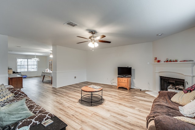 living room featuring wood-type flooring and ceiling fan with notable chandelier