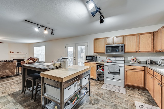 kitchen featuring white electric range, french doors, and rail lighting