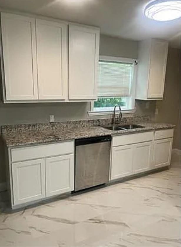 kitchen with stone counters, stainless steel dishwasher, and white cabinets