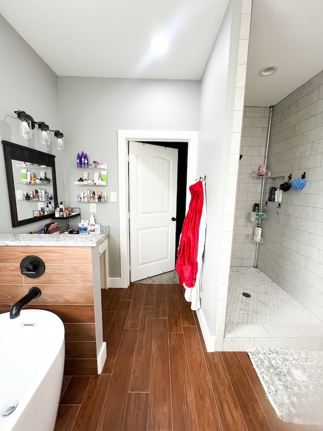 bathroom with hardwood / wood-style flooring, shower with separate bathtub, and vanity